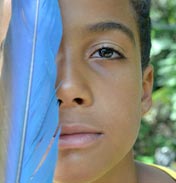 Foto de menino negro com uma pena azul sob o olho esquerdo.